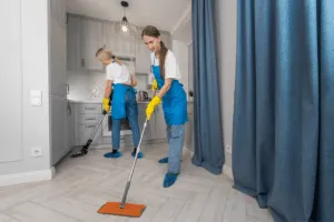 Due addette alle pulizie che puliscono la cucina