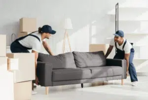 due facchini che provano ad alzare un divano a due posti