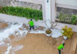 Due addetti alle pulizie che lavano l'esterno di un condominio